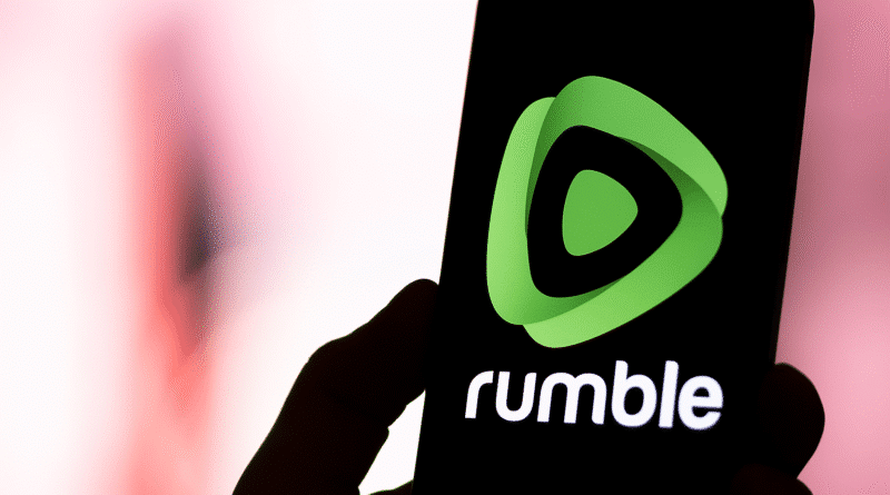 Rumble to Acquire Northern Data as Tether Commits $150 Million in AI GPU Deal person holding a phone with the rumble logo