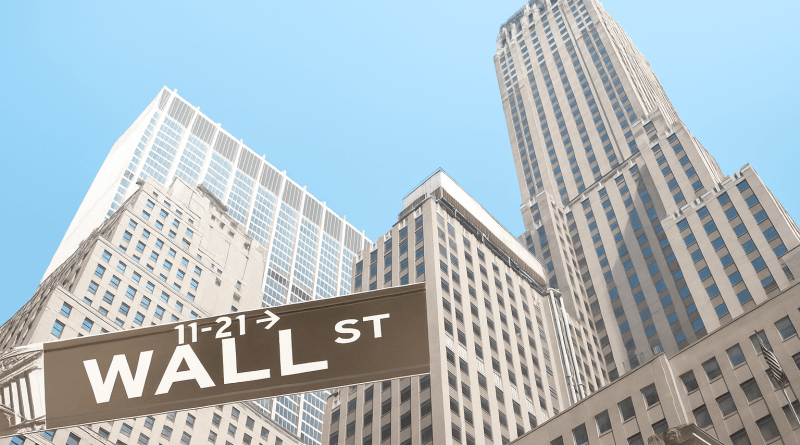 wall street sign with skyscrapers in the background